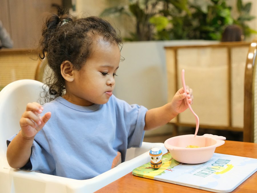 Toddler eating with a spoon at the table